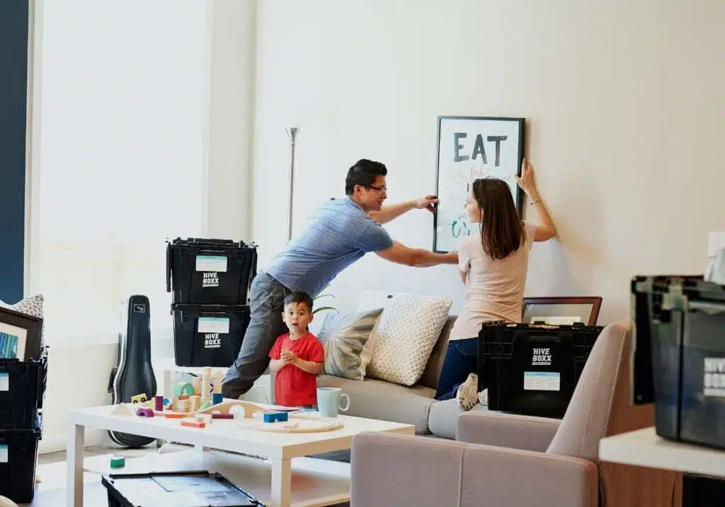 Familia colocando cuadro con buena postura